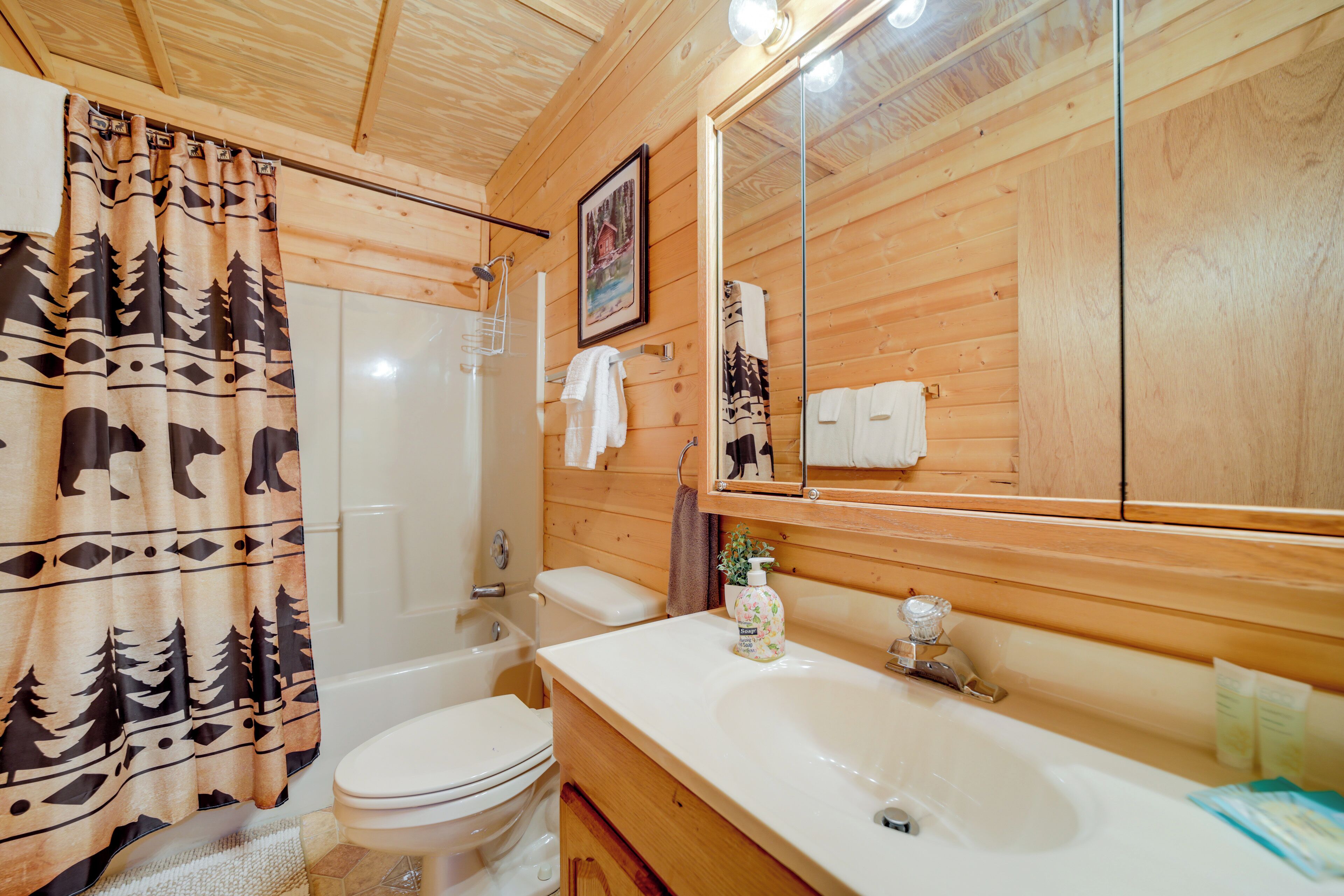 Une salle de bain rustique, aménagée dans une cabane en bois, avec des toilettes, un lavabo et une douche.