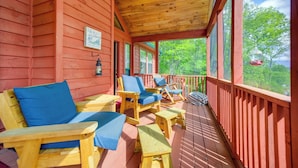 Eine Holzterrasse mit Sitzgelegenheiten, darunter Stühle und ein Tisch.
