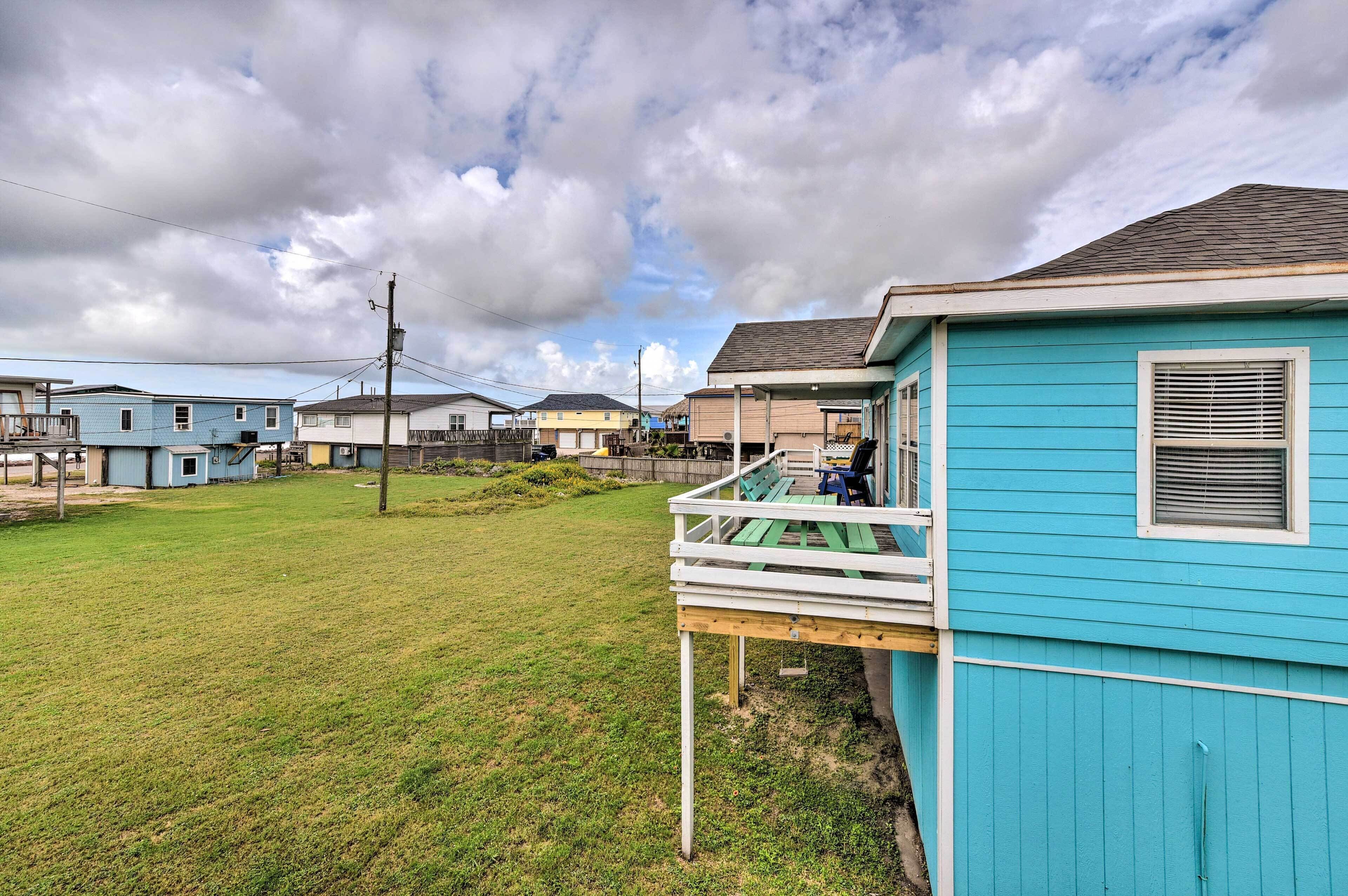 A residential area with houses, a grassy yard, and a porch with a bench.