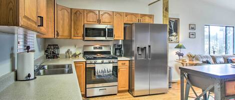 A kitchen with wooden cabinets, stainless steel appliances, a built-in oven, and a refrigerator.