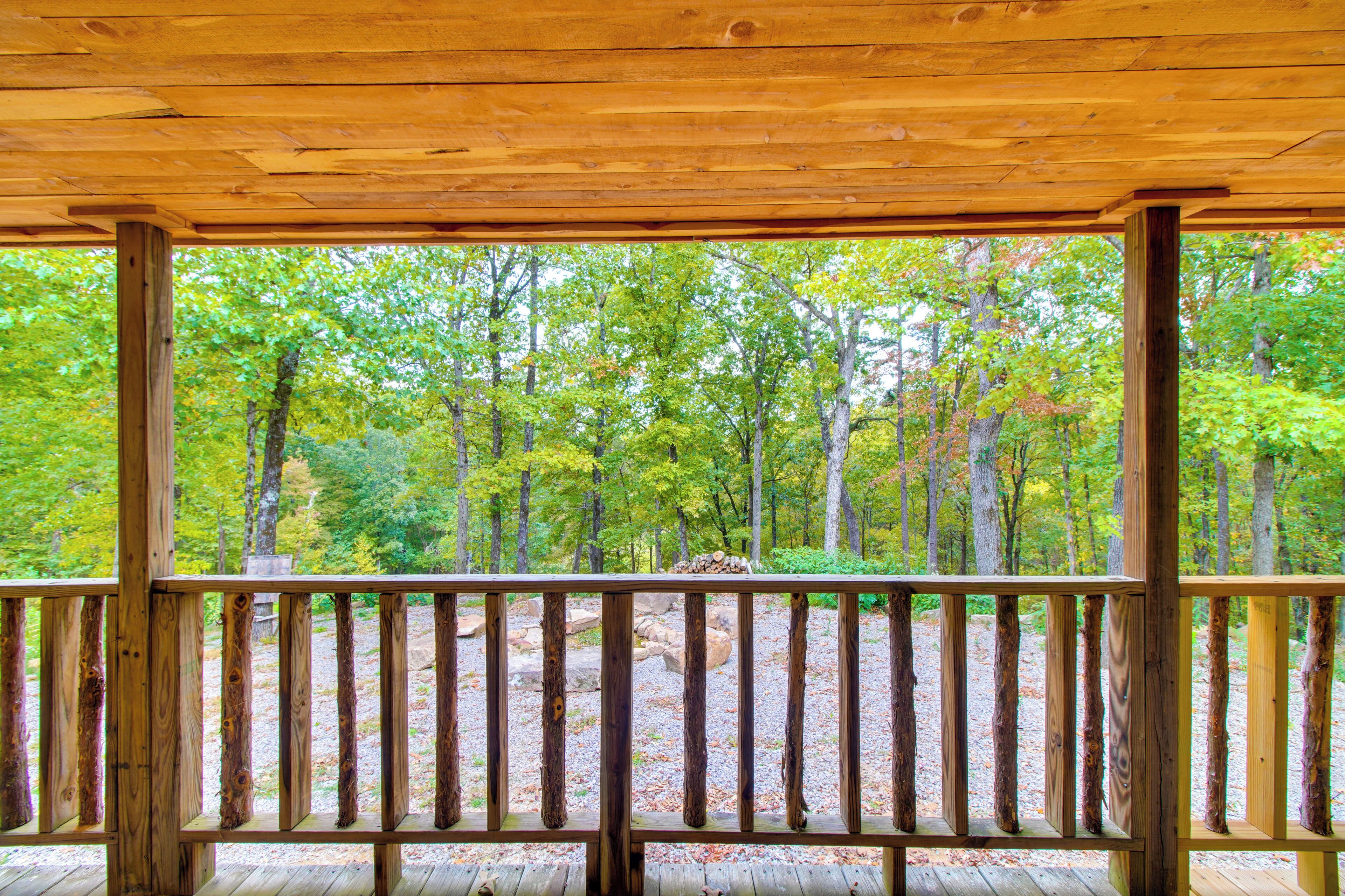 A wooden deck with a view of a forest.