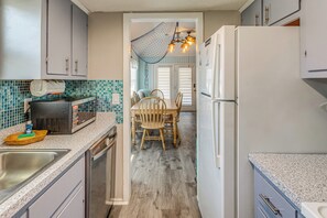 A kitchen with a dining area, a refrigerator, and a microwave.