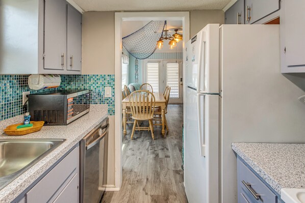 A kitchen with a dining area, a refrigerator, and a microwave.