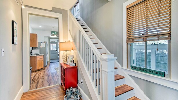 A staircase with white railings and wooden steps leading to a landing.