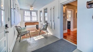 A spacious hallway with a wooden floor, a bench, and a chair.