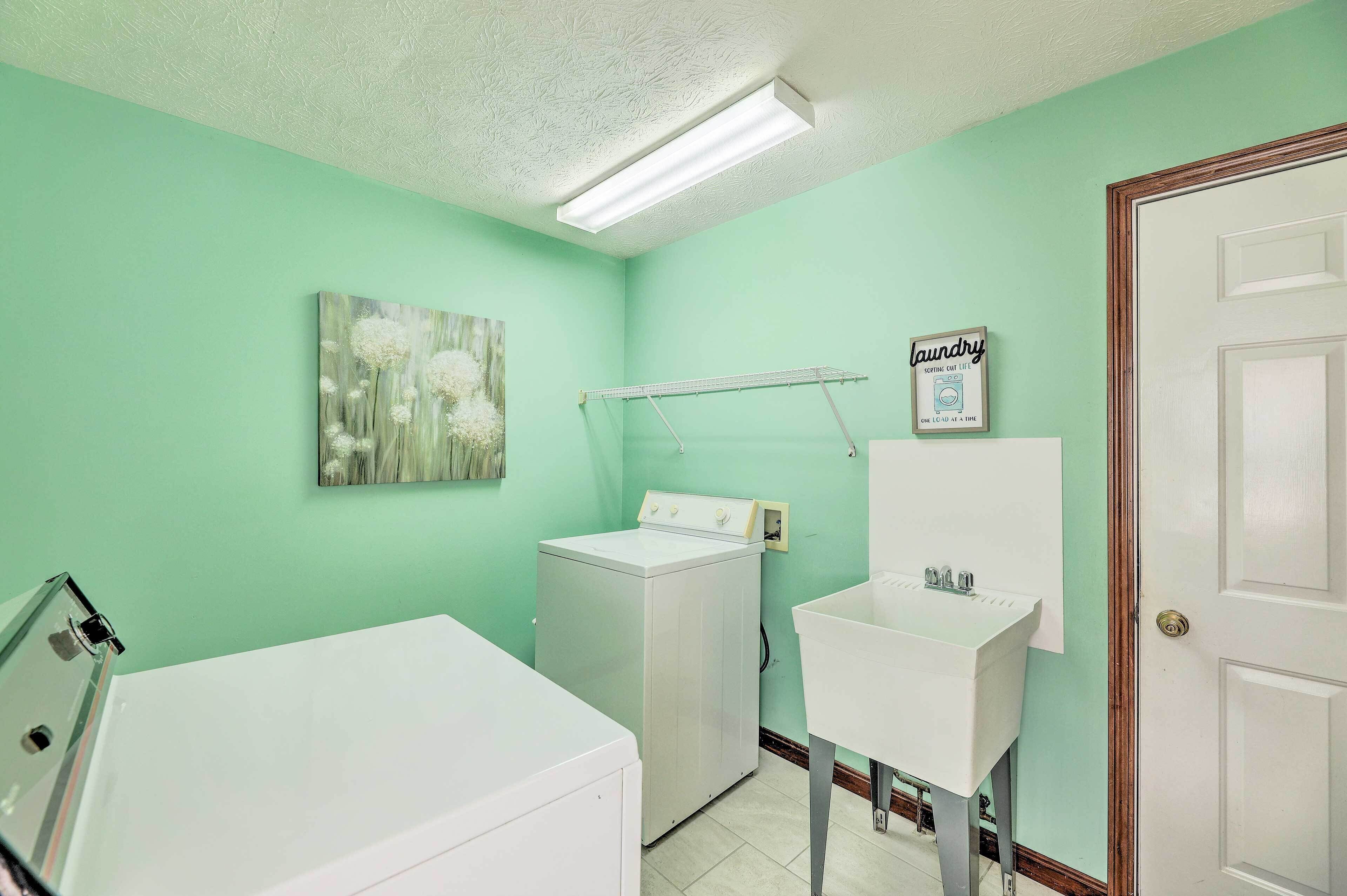 A laundry room with a washing machine, dryer, and a sink.