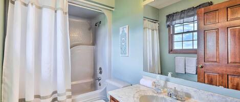A bathroom with a bathtub, toilet, and sink.