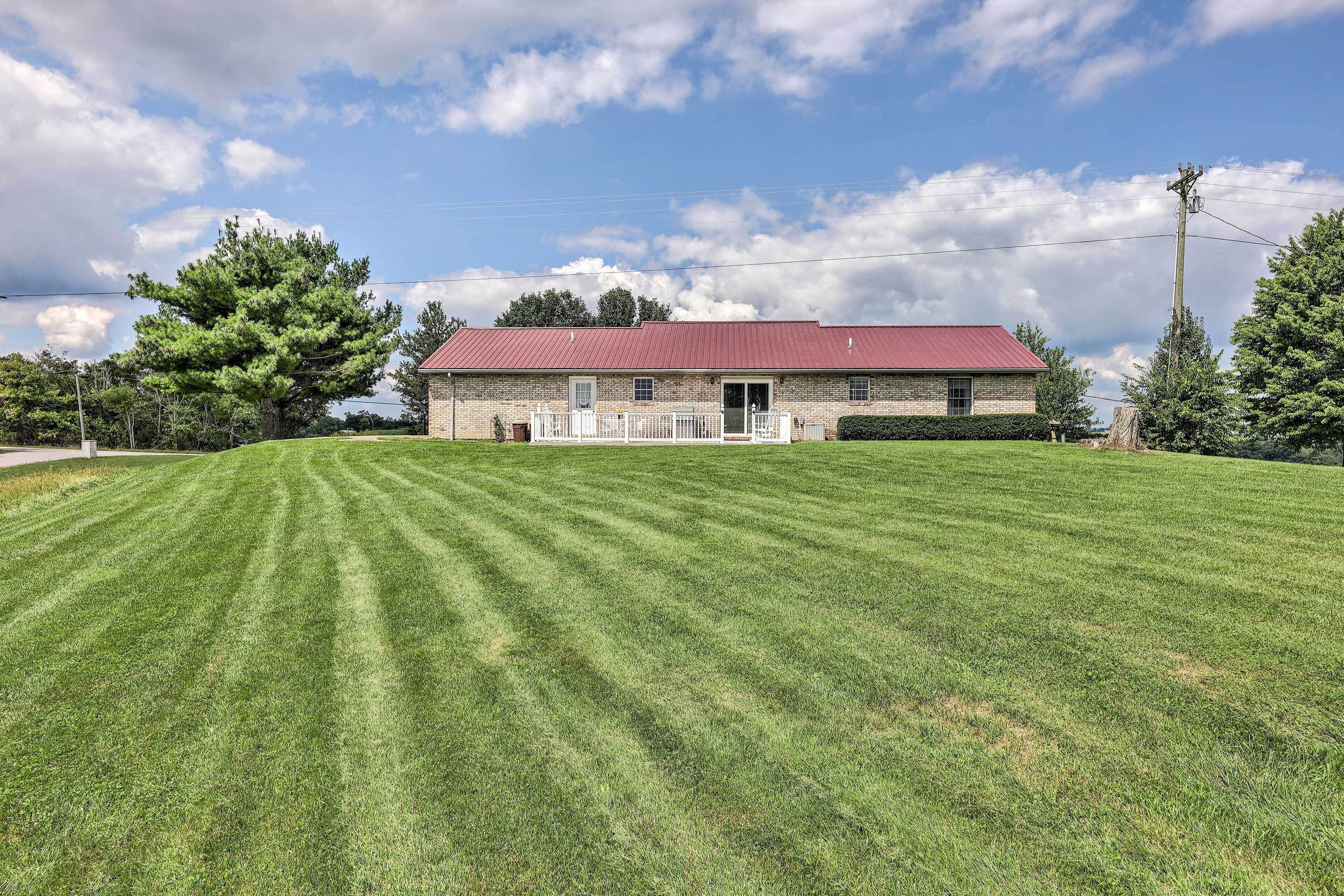 A two-story building with a red roof, a front porch, and a well-maintained lawn.