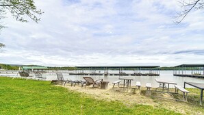 Een park aan het meer met picknicktafels, stoelen en een overdekte ruimte.