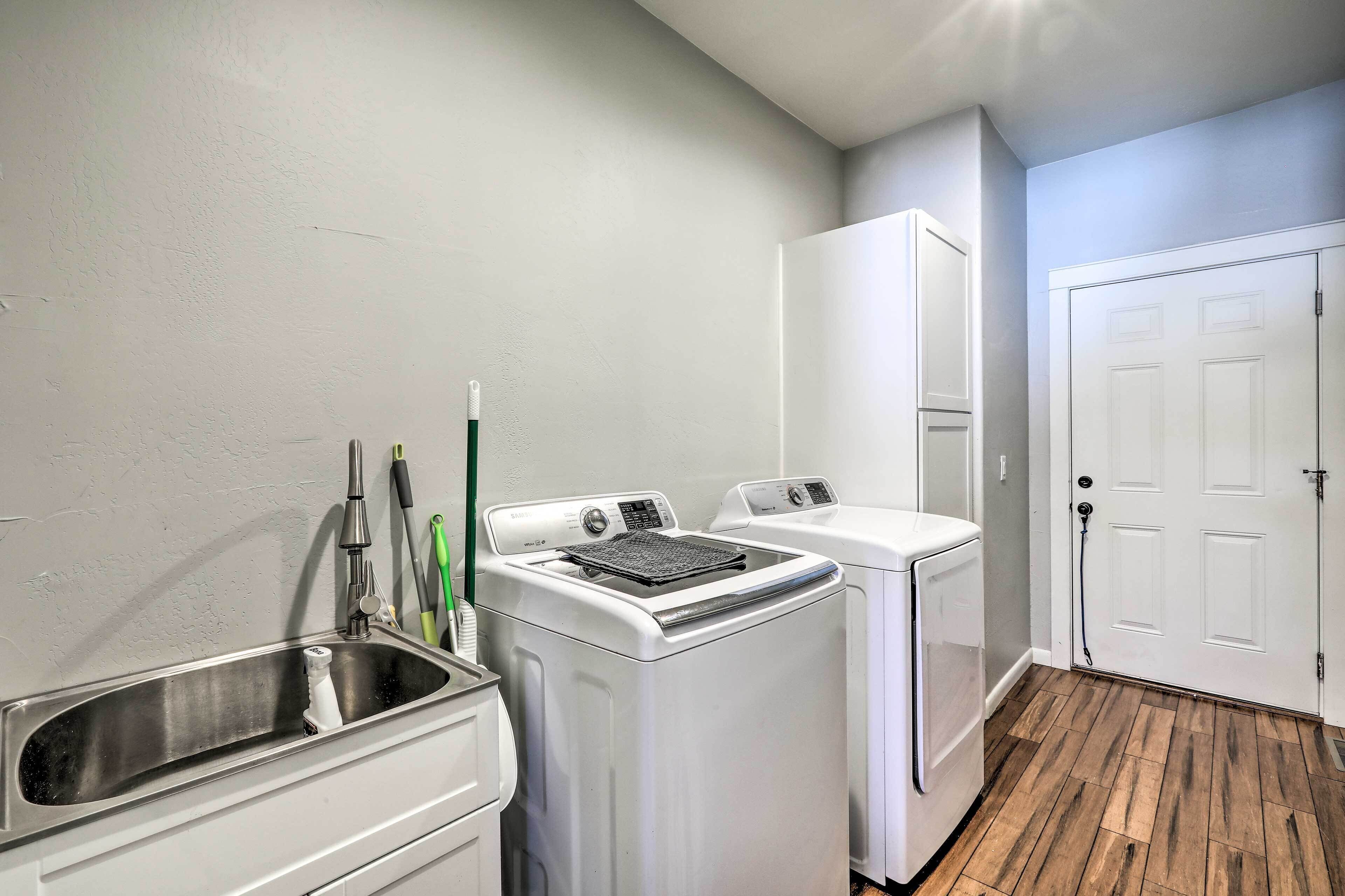 A laundry area with a washing machine, dryer, and sink.