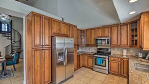 A kitchen with wooden cabinets, stainless steel appliances, and a granite countertop.