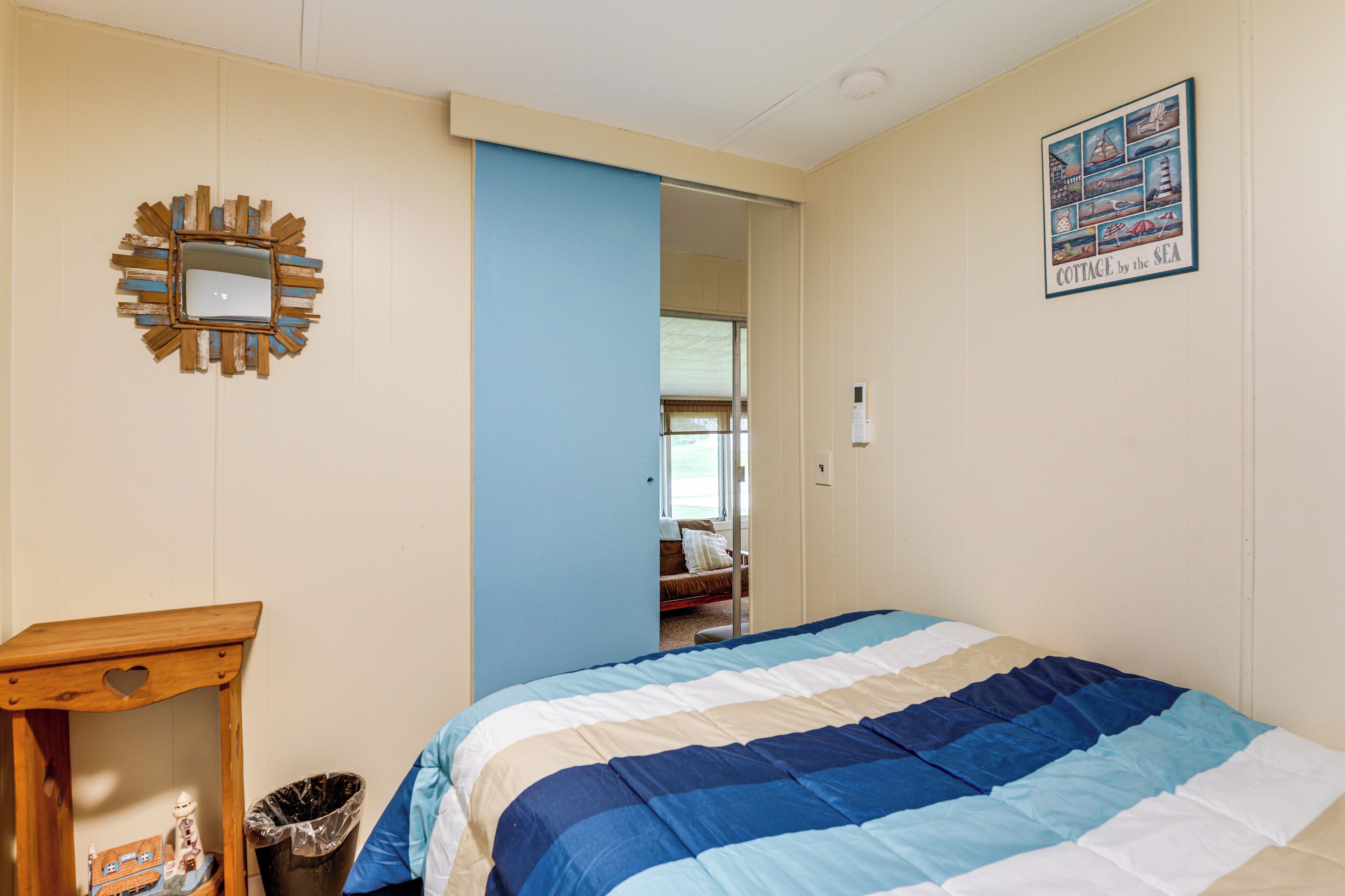 Un dormitorio con cama, cómoda, espejo y puerta que da a otra habitación.