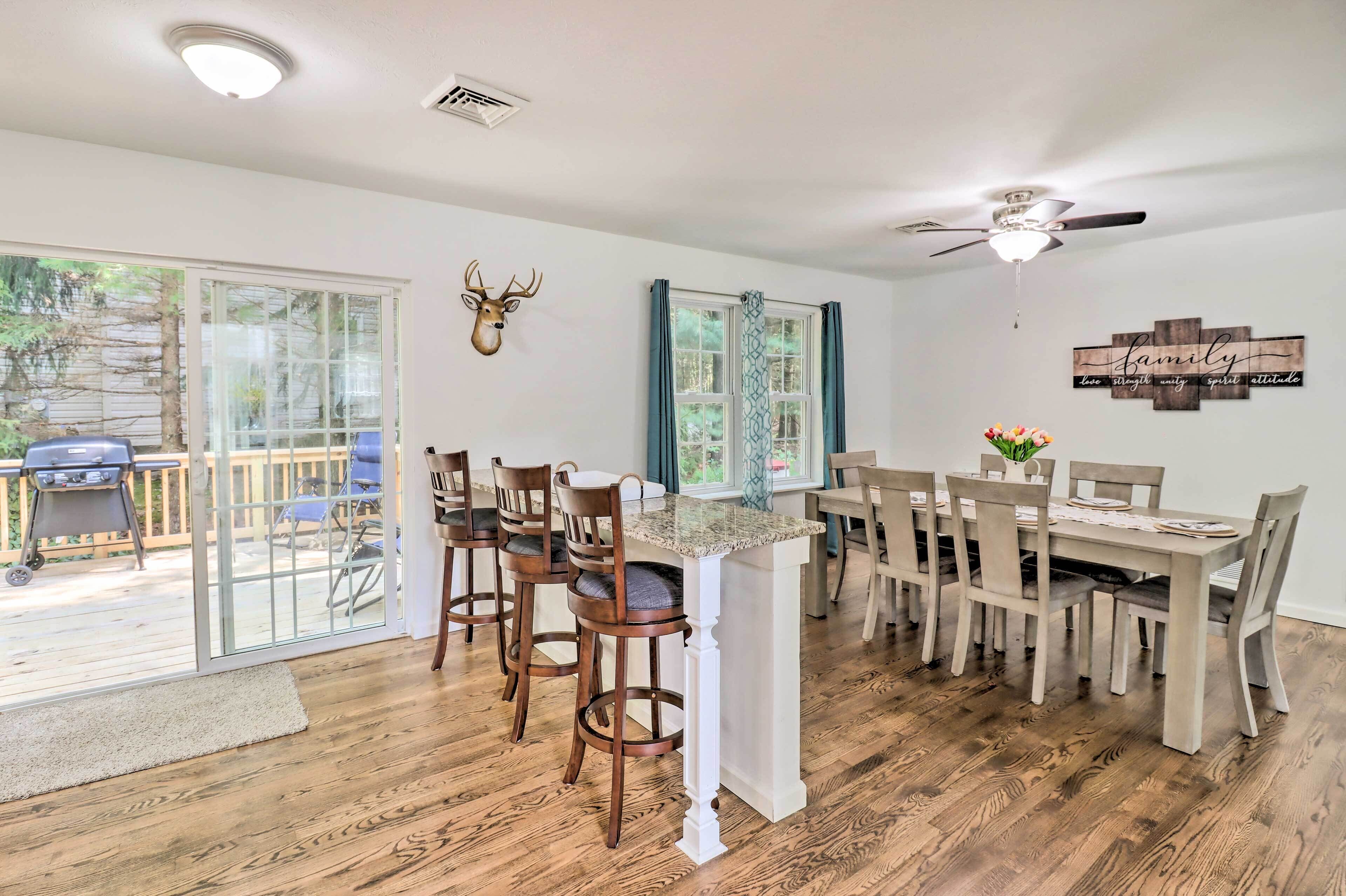 Un espace repas comprenant une grande table, des chaises et un ventilateur de plafond.