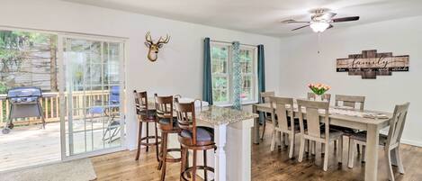 Un espace repas comprenant une grande table, des chaises et un ventilateur de plafond.