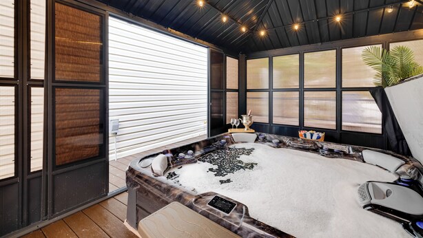 A spa area with a hot tub, seating, and large windows.