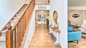 A staircase with a wooden handrail leading to a landing with a 'welcome' sign.