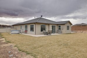 A single-story house with a covered patio, a barbecue grill, and a small outdoor seating area. - Modern Vacation Rental Near Zion National Park! (La Verkin)