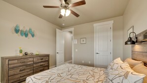 A bedroom with a bed, dresser, ceiling fan, and two doors. - Modern Vacation Rental Near Zion National Park! (La Verkin)