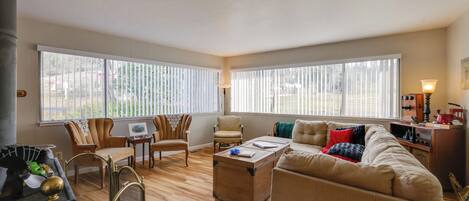 A spacious living room with a large sofa, two armchairs, a coffee table, and a fireplace.