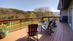 A wooden deck with a view of a golf course and hills. - Deck, Grill & Mountain Views: Banner Elk Retreat! (Banner Elk)