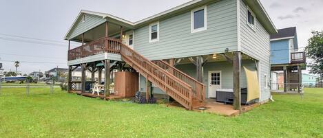 Une maison à deux étages dotée d’une terrasse en bois et d’un escalier menant à l’étage supérieur.