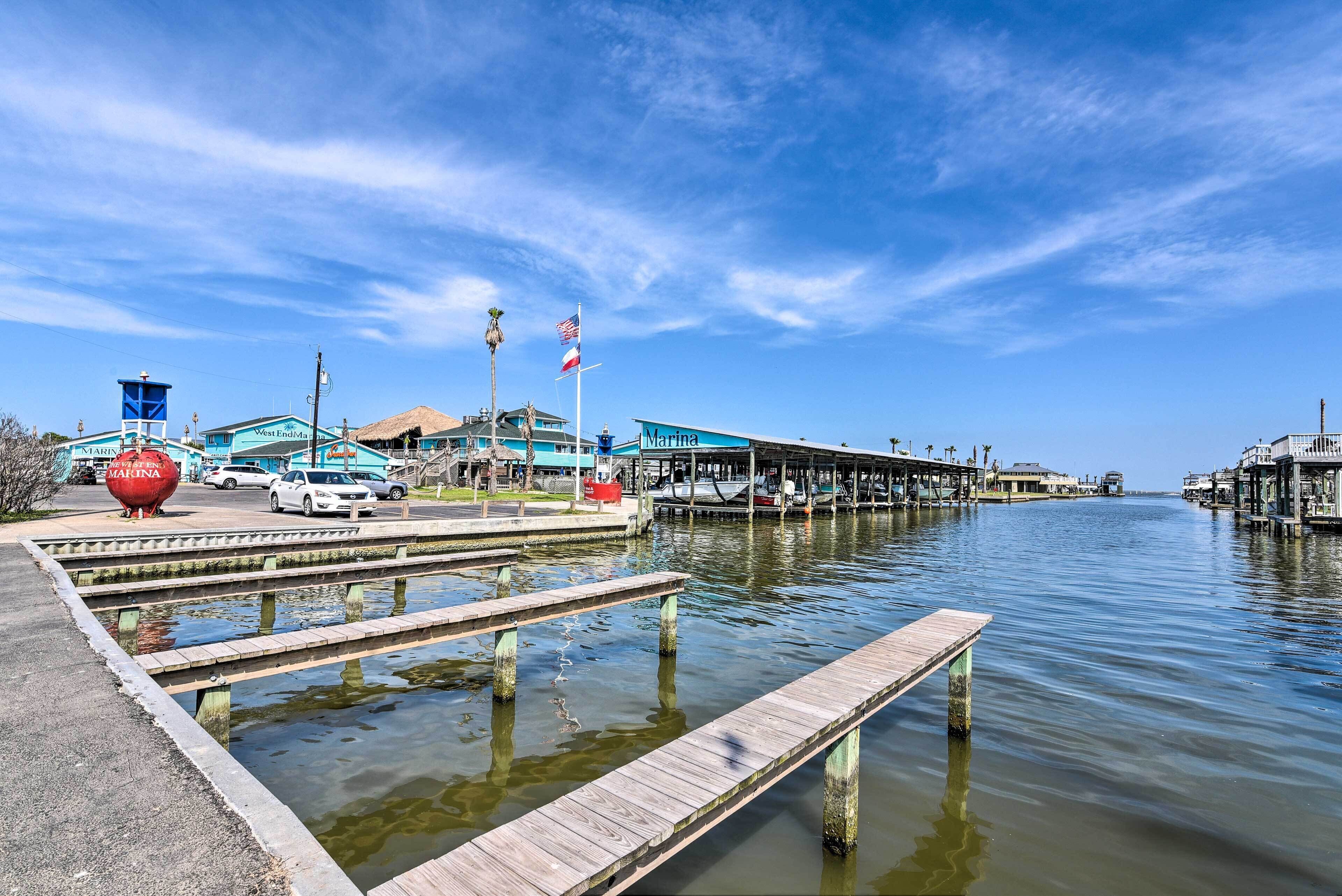 A marina with docked boats, a clear sky, and a wooden pier.