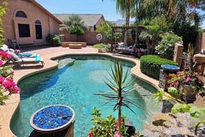 A swimming pool with a curved edge, surrounded by a patio area with lounge chairs and a pergola. - Chandler Resort Home w/ Private Pool Near Golf (Chandler)