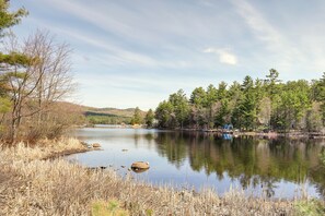 A calm lake surrounded by trees and hills.