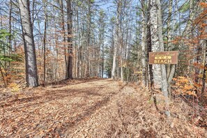 A forested path leading to a sign for Labayevia Point H.O.A. Beach.