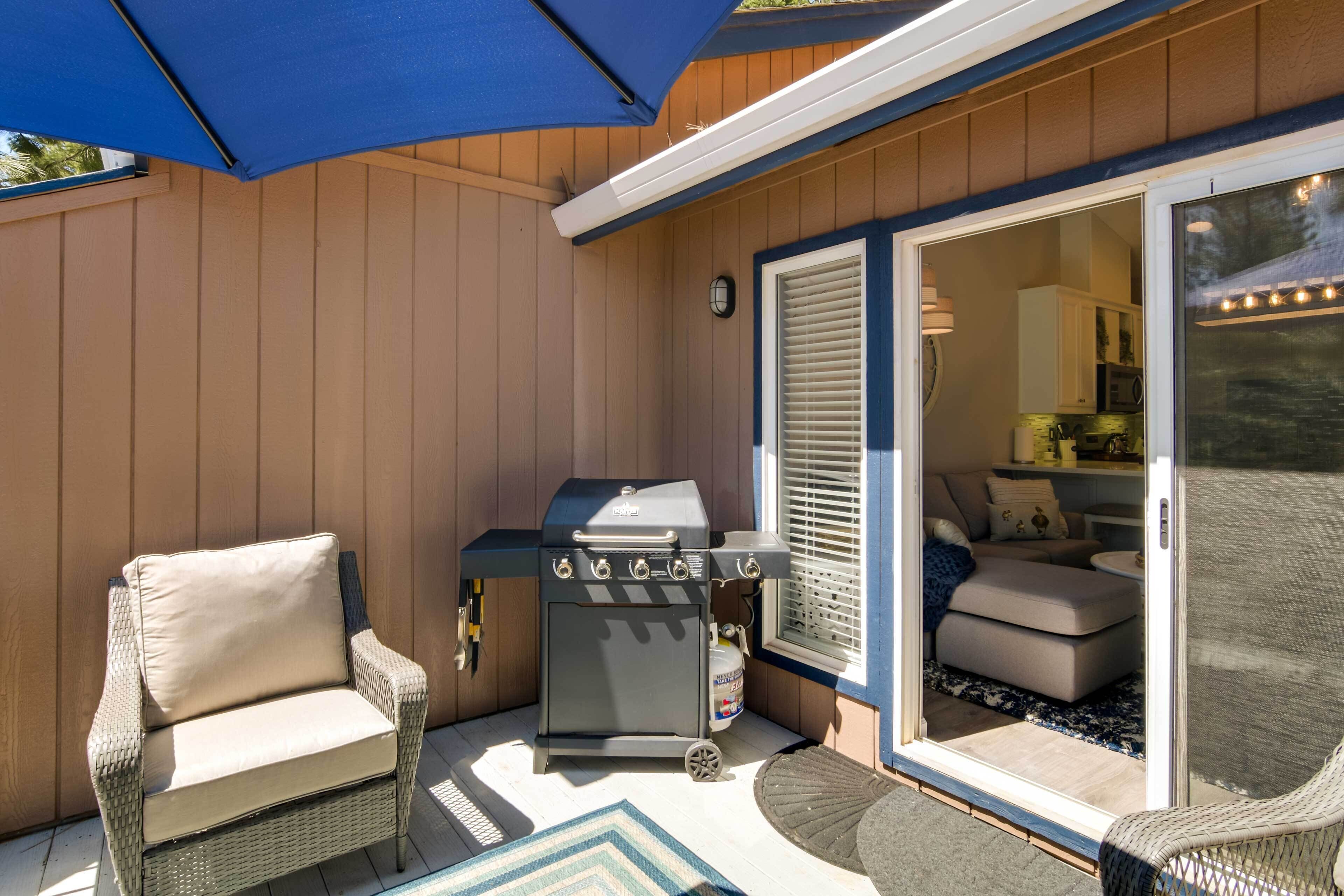 A covered patio with a grill, wicker chairs, and a sliding glass door leading to an interior space.