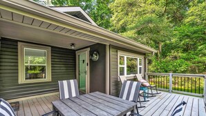 A wooden deck with a table and chairs, a door, and a window. - Pet-friendly Pickens Vacation Rental w/ Fire Pit (Pickens)