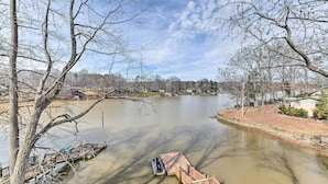 Ein Fluss mit angestaubten Booten, eine Holzbrücke und kahlstehende Bäume.