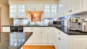 A kitchen with white cabinets, a granite countertop, a mosaic backsplash, and modern appliances. - Cozy Lewiston Home < 10 Mi to Niagara Falls! (Lewiston)