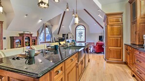 A spacious kitchen with a large island, wooden cabinets, and pendant lighting. - Historic Guest House on Castle Kimble Estate! (Manhattan)