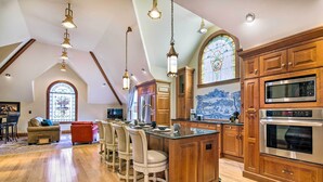 A spacious kitchen with wooden cabinets, a large island, and a built-in oven. - Historic Guest House on Castle Kimble Estate! (Manhattan)