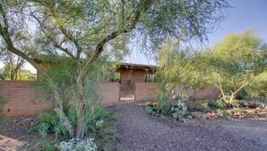 A building with a brick exterior, a gravel driveway, and a wooden gate. - Tucson Home - Hiking Trail Access On-site! (Tucson)