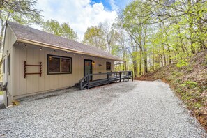 A building with a gravel driveway, wooden steps, and a metal railing.