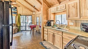 A wooden cabin kitchen with a stove, sink, and cabinets. - Lakeside Cabin w/ Fire Pit ~ 4 Mi to Show Low Lake (Lakeside)