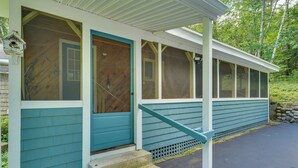 Une maison avec un porche, une porte d’entrée et un escalier menant à l’entrée.