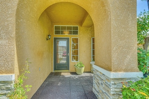 A building entrance with a stone foundation, a door with a window, and a potted plant. - Peaceful Fresno Home, Near Popular Wineries! (Fresno)