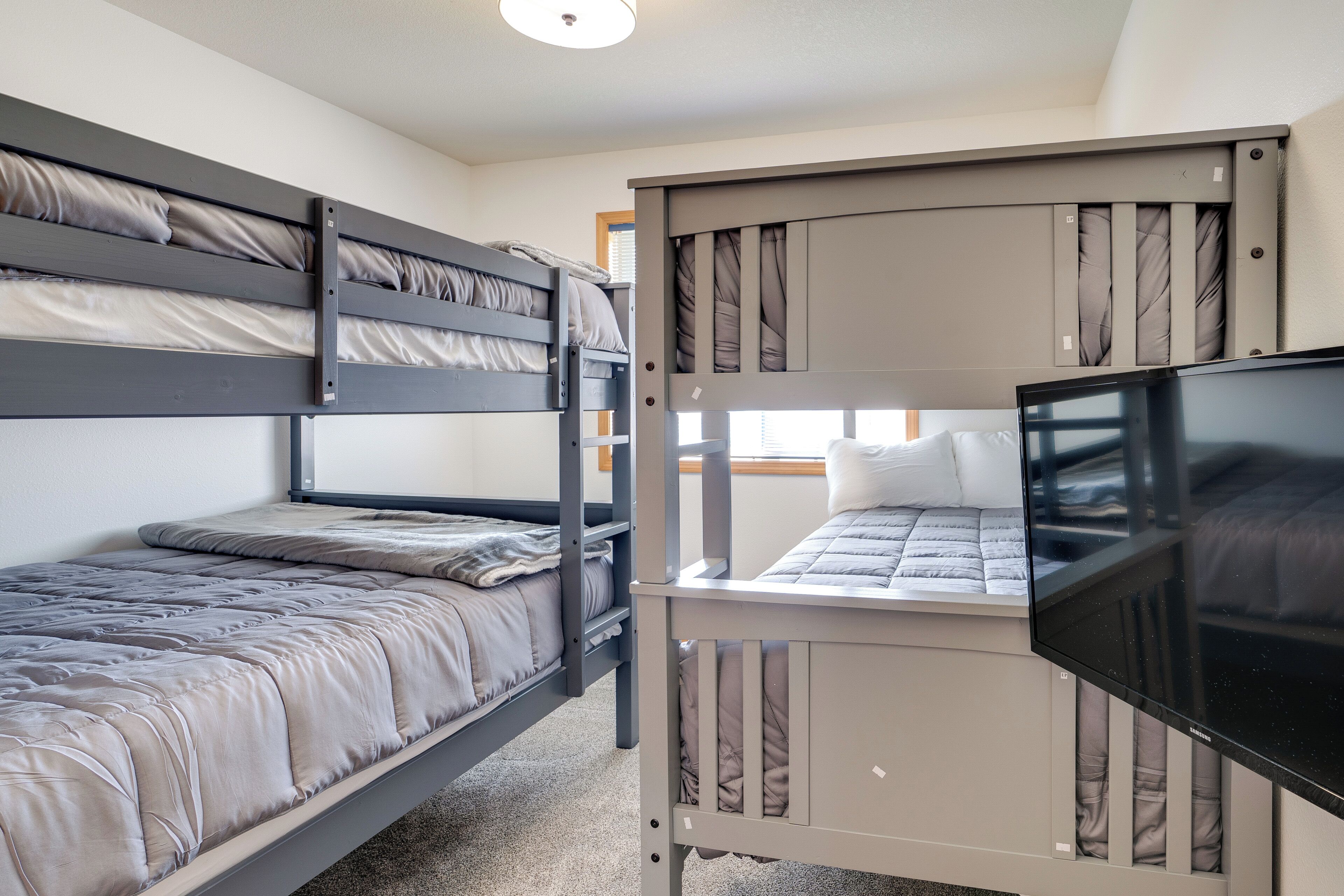 A bunk bed room with a television on the lower bunk.