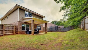 A two-story house with a covered patio, a brick exterior, and a fenced backyard. - Huntsville Vacation Rental < 5 Mi to Airport! (Huntsville)