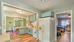 Une cuisine de taille réduite avec un plancher en bois, un réfrigérateur et des armoires bleu clair.