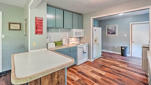 Une cuisine avec des armoires de couleur turquoise, un réfrigérateur blanc et un four à micro-ondes.