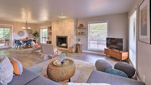 A spacious living room with a fireplace, a dining area, and a television.