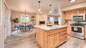 A spacious kitchen with wooden cabinets, a large island, and a built-in oven.