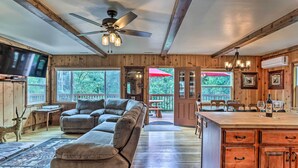 A spacious living room with a large sectional sofa, a wooden ceiling, and a ceiling fan. - Rustic Oakhurst Retreat < 4 Mi to Bass Lake! (Oakhurst)
