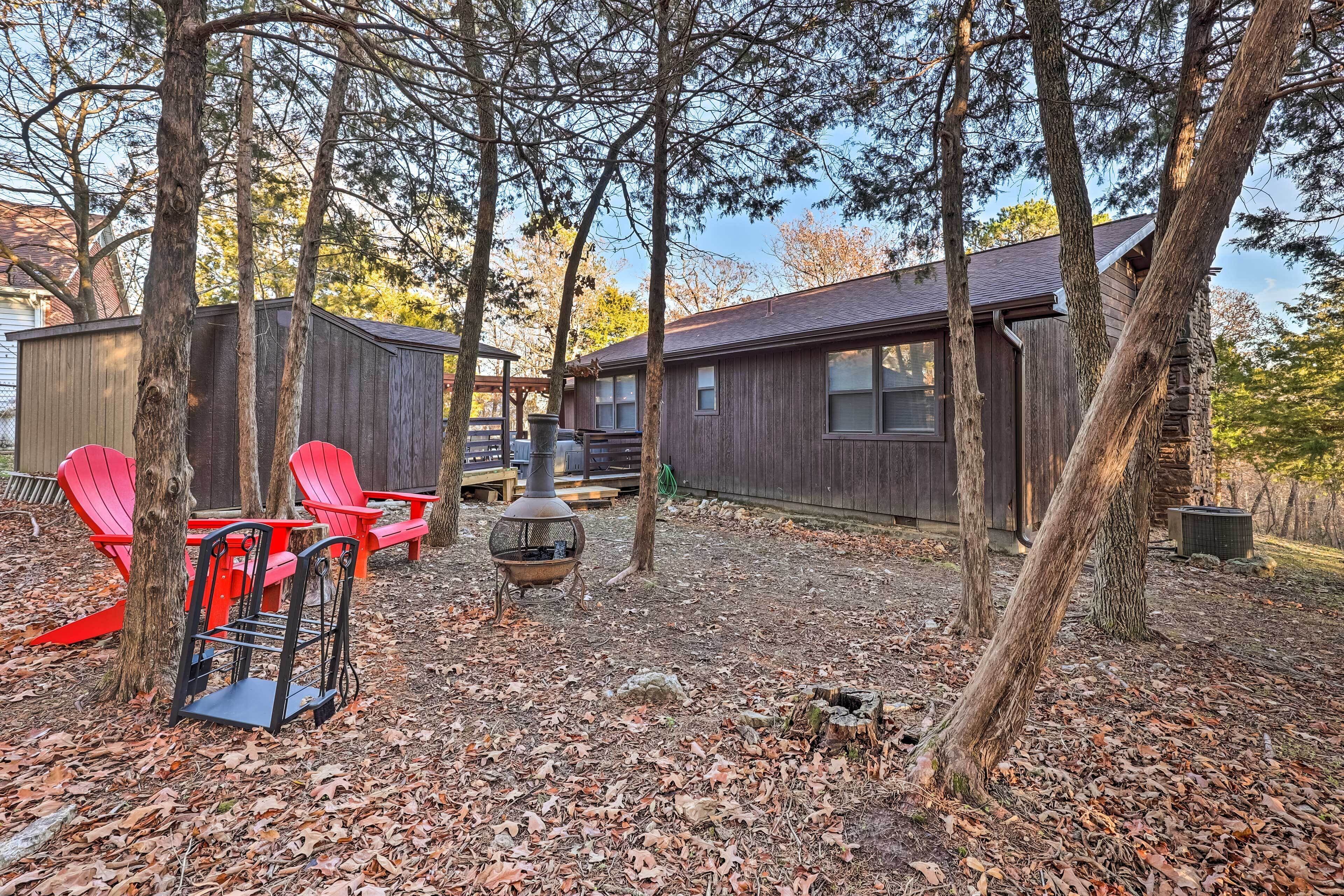 A rustic cabin with a wooden exterior, surrounded by trees and covered in fallen leaves.