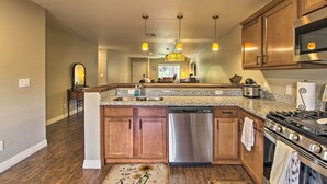 A kitchen with wooden cabinets, stainless steel appliances, and pendant lighting.