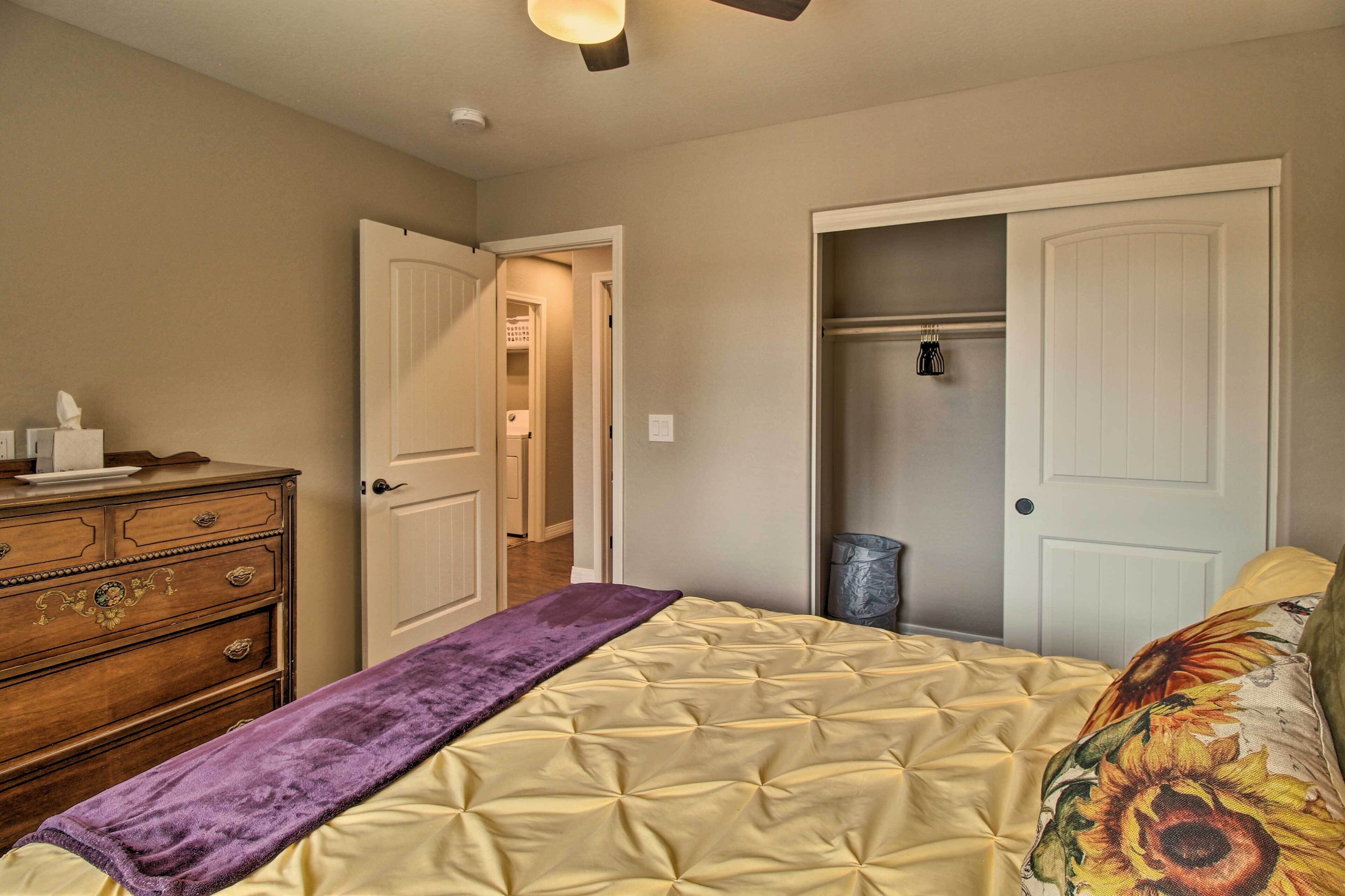 A bedroom with a bed, dresser, and closet.